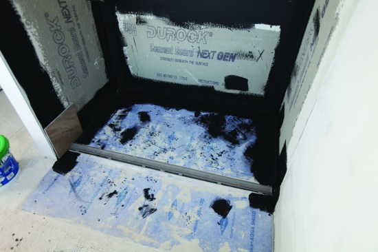 An approved mesh was applied at the seams with thinset, then the walls were waterproofed with Laticrete 9235.