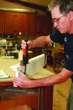 After applying a thin line of glue to the top of the frieze, clamp the crown to the frieze, making sure the crown is flush with the back of the frieze and proud an equal amount at each end.