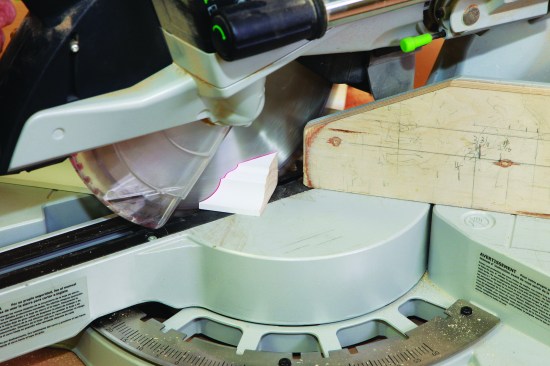 I cut the first self-return cap for the crown. Next, I swing the saw, and cut an outside-corner miter.