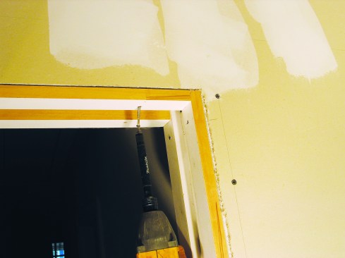 I cut and fit the split jambs next to the jamb side of the opening, letting them extend up to the header/track. Then I screwed in the horizontal split-jamb pieces between the vertical jambs.