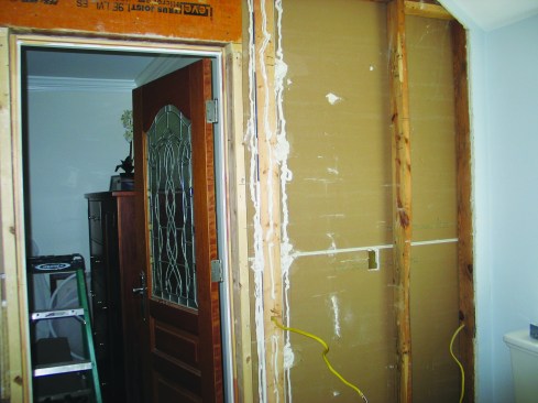 Removing the intersection stud left the edges of the drywall on both sides of the perpendicular wall unsupported, so I spread construction adhesive on the entire area and installed a backer board.