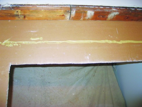 Before installing the header, I put construction adhesive on the back of the drywall where the header would bear against it.