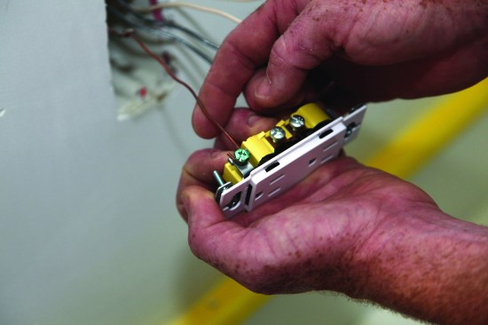 The author attaches the ground conductor first. First he slips the loop
around the grounding screw.