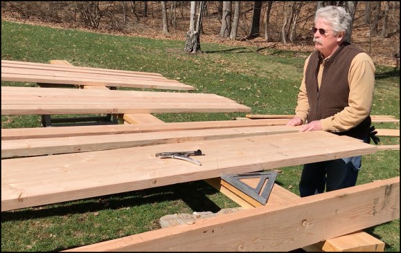 With the help of my son, Kyle, I laid out a group of five 2x6s for the jacks (one group includes enough material to frame one corner of the hip roof). To minimize any bow in the rafters, we faced the crowns of the stock towards the middle 2x6, the center rafter being the straightest one.