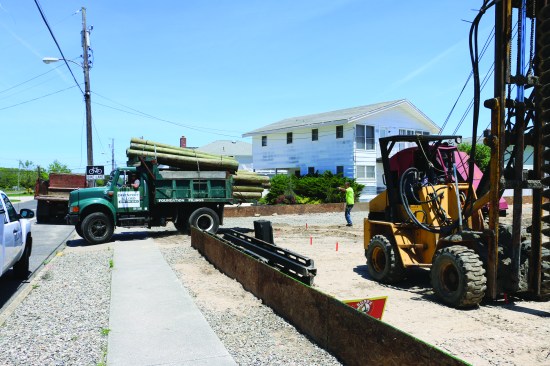 A dump truck delivers the pilings, the length and diameter of which are based on the soil requirements.