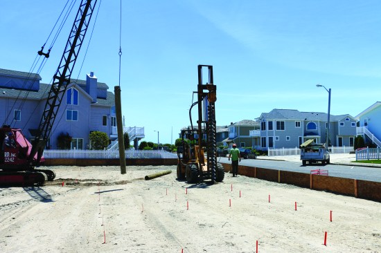 A long auger digs a hole at each location.
