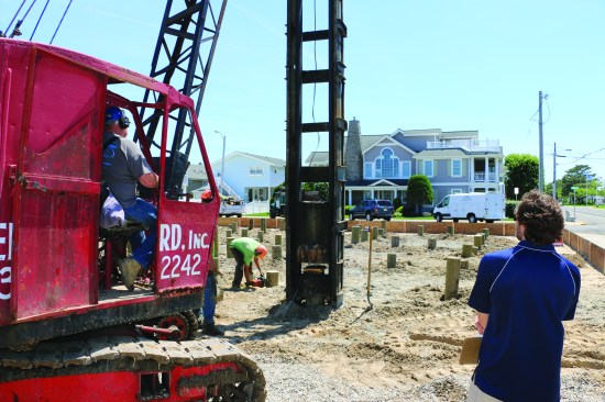 The crane raises the hammer and drops it on the piling, while the engineer witnesses and records each piling.