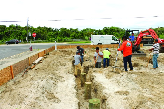 The crew follows, evening out the floor of the trench with shovels to prep for the concrete. The crew keeps the depth of the trenches consistent using a laser level.