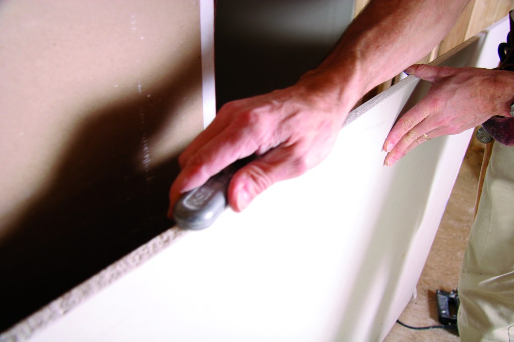 A drywall rasp can clean up a rough edge.