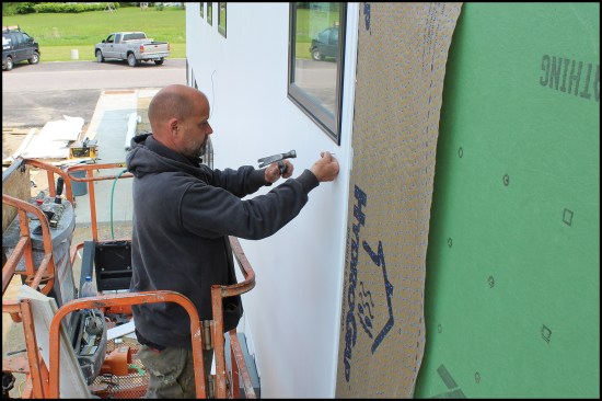 Due to wind, the HydroGap WRB was installed vertically on the north elevation as the siding was installed. The author nailed by hand near windows to avoid damage to underlying flanges and flashings (the vertical siding run to the window frame).