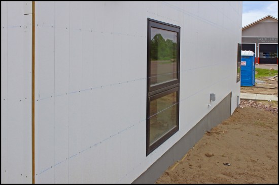 With the vertical siding installed, the author snapped lines to help line up the final 16‑inch-o.c. face-nailing. Also of note, the vertical siding lapped over a fiberglass-reinforced plastic protection barrier, “Groundbreaker” by Nudo, at grade.