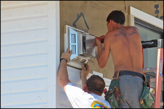 Large penetrations were blocked with Boral; head trim was run over jamb trim. The fan unit’s flange set in sealant.