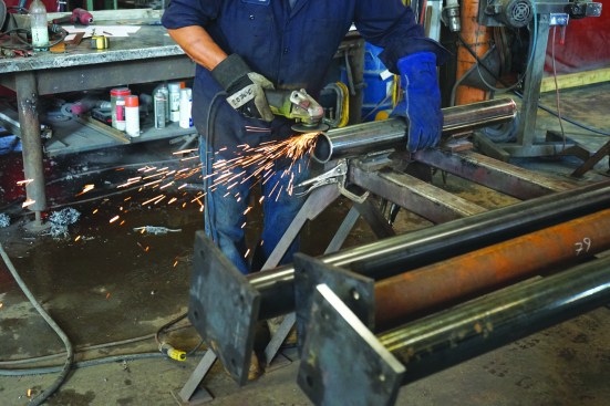 The fabricator then cleans the end of the column with an abrasive wheel.