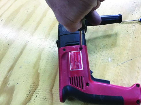 To access the switch, the author removes the screws holding the handle together.