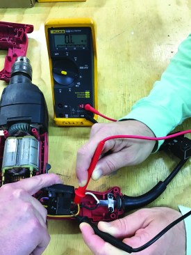 To confirm that the switch is bad, the author depresses the switch while a helper checks the continuity through the switch.