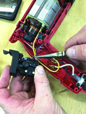Reversing the process, the author uses needle-nose pliers to insert wires into their slots.