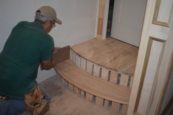 At the ends of the tread, the author uses a block of 3/4-inch thick stock to scribe the ends of the tread to fit around the skirt boards.