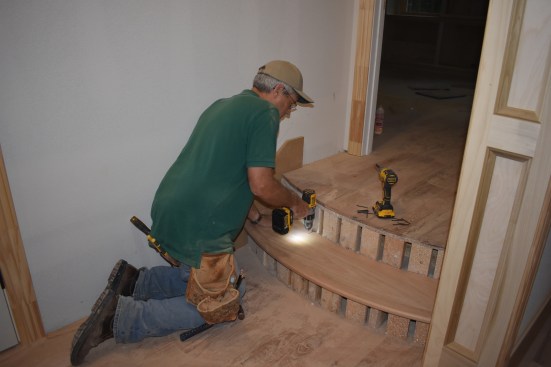 The author drills holes for the finish screws that will hold the tread in place until the glue dries. 