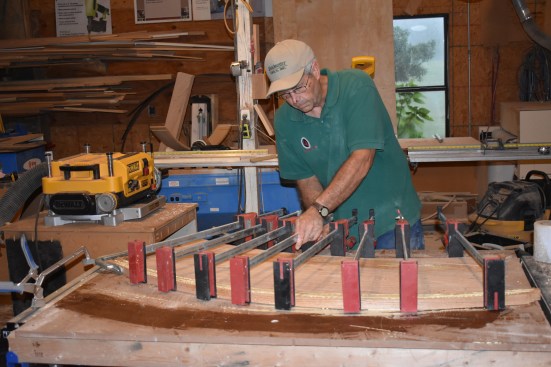 Using the curved step blank as a form, the author clamps on the stacked strips to take the curve.