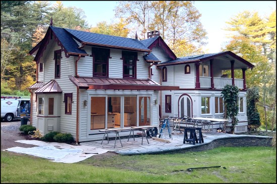 The completed Carpenter Gothic-inspired addition with stepped back second-floor wall. The sight lines from the second-floor bathroom archtop window in the remodeled portion of the existing home no longer blocked.