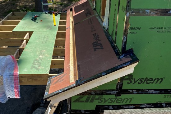 The 19 1/2-foot-long rough gutter was built on the ground in two 9-foot-9-inch-long sections out of pressure-treated 1-by stock. The two trough sections were joined at the center (all seams were glued and screwed) and the completed gutter was lifted in place.