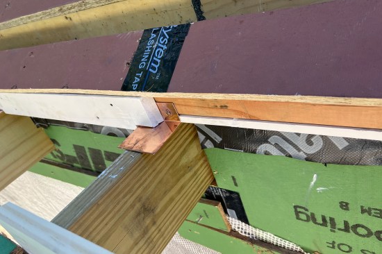 At the trellis, the roof’s edge is nearly in line with the face of the exterior wall below. The trellis’s cantilevered framing made the installation of a conventional gutter impossible to pick up the water and prevent icing on the kitchen’s slider step below.