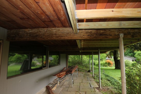 Viewed from below, the new parallam and flush-framed deck framing. The home’s “cantilevered” main-level floor is seen to the left of the doubled-up 2-by ledger, the new infill framing and decking to the right. The new PSLs were inserted in the pockets vacated by the demoed fir beams at the grade-level wall, seen of the far left.
