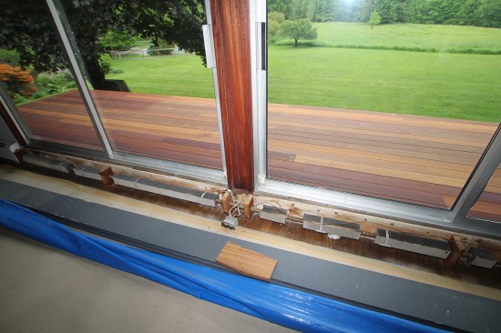 The 5⁄4x6 mahogany decking, installed with hidden fastening clips, served as a work platform to replace the existing sliders. The raised thresholds needed to accommodate hydronic baseboard were also removed.