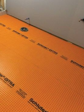 An uncoupling membrane is thinset to the underlayment.