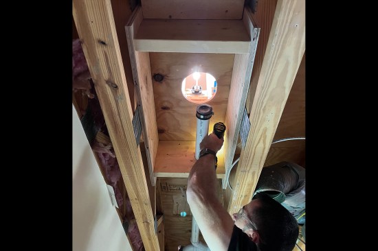 The author installs blocking between existing floor trusses under a barrier-free shower to prevent flexing of the subfloor.