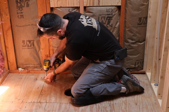 He fastens the joist bay blocking from above, as well.