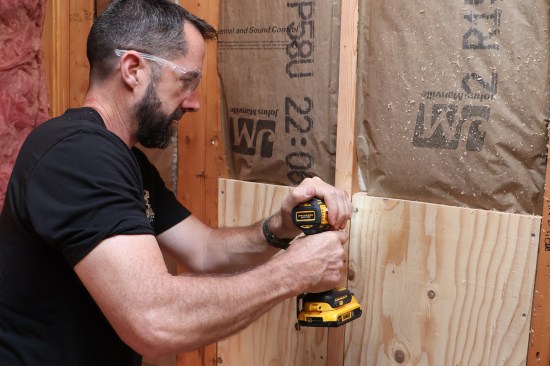 Plywood blocking helps lessen compressing of batts in exterior wall cavities and provides a greater area and more flexibility for mounting accessories. Blocking is screwed to cleats ripped from 2-by stock.