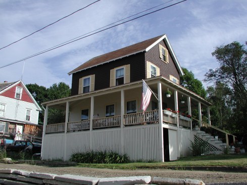 The project house before demolition of the existing porch. Drainage on site was an obvious problem; hidden issues with the foundation piers soon came to light.