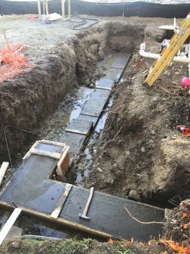 The new footing for the porch foundation and retaining wall sits in the wet trench. Drainage is a problem on this site, which is located just a stone's throw from the salt water of the Casco Bay.