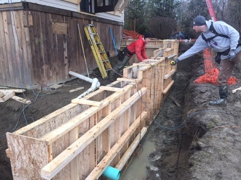 Wooden forms for a new foundation wall, designed to allow for re-grading the site as well as supporting the reconstructed porch and kitchen addition.