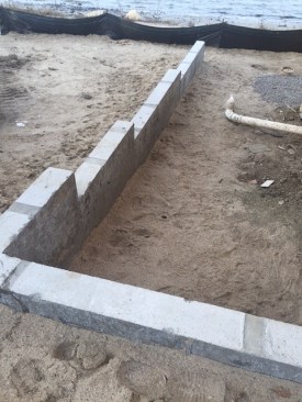 The poured concrete foundation wall after backfill. This wall is designed as a retaining wall, but fill could not be added to the site because of environmental rules.