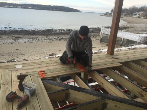 With the house temporarily supported on jacks and the new post structure framed in for the post, the crew hurried to build the new porch before winter weather set in. To the rear is the Casco Bay, just a few feet away from the property.