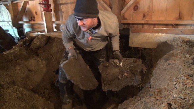 Chris pulls chunks of ice out of the excavation.