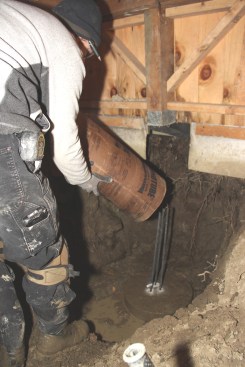 Chris sets a new Sonotube into place over the newly set rebar in the precast footing pad.