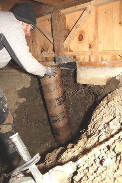 Chris sets a new Sonotube in place on the precast pad, slipping the tube over the steel reinforcement.