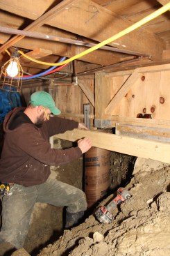 Shane checks his newly placed Sonotube for plumb before screwing the tube to the temporary 2x6 cross brace.
