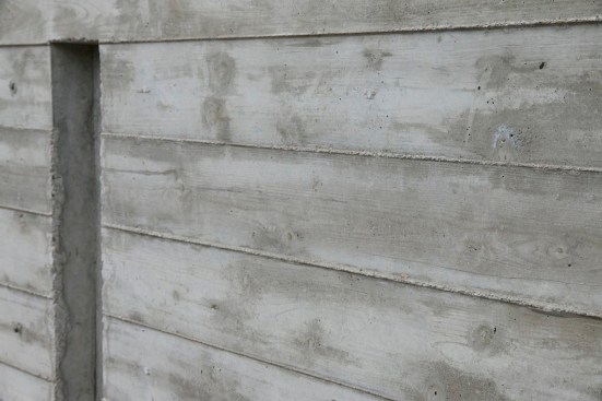 The grain and texture of the individual form boards telegraph in reverse onto the surface of the concrete.