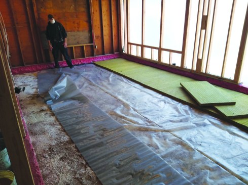 The author generously dusted the compacted earth with diatomaceous earth to protect against insects, laid down a 10‑mil vapor barrier, and topped it with 2-inch (R-8) Rockwool Comfortboard 110. A woven vapor barrier was installed over the Comfortboard.