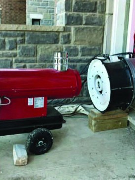 A portable heater blows directly into the blower-door fan—Gorde Cooke’s solution for extending the installation season for AeroBarrier in a cold climate.