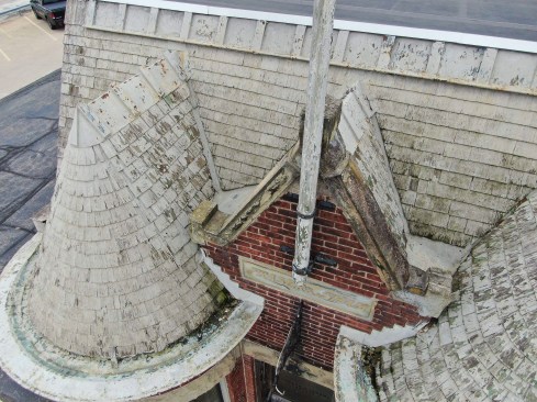 Existing conditions. Elastomeric paint had been smeared over the shingles, valleys, gutters, and ridge caps in a poor attempt to increase the life of roof.