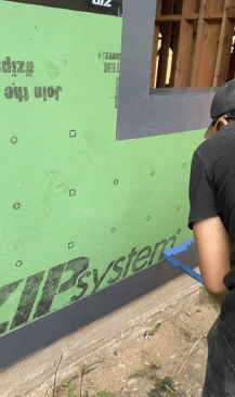 At the base of the wall, the author’s crew uses painter’s tape to establish a clean line at the top and the bottom.
