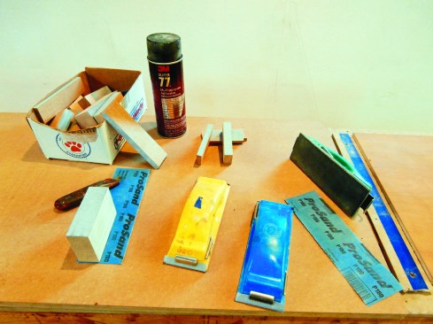For sanding bare wood, the author relies primarily on a random orbit sander, but on most projects he can’t avoid hand sanding. Then he uses Preppin’ Weapons—colored rubber blocks (each color is a different grit). For detail work, he uses a spray adhesive to attach sandpaper to a variety of wood blocks.