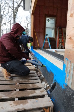 Prep work begins with creating a sill pan with liquid-applied flashing.