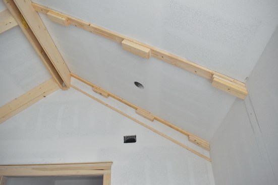 On the ceiling, 2x6 blocking is installed to the backing with close attention to the layout lines.