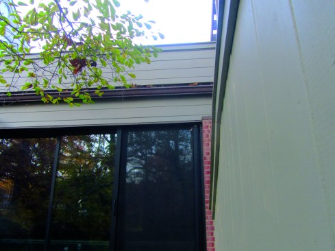 As seen from the ground, the gutter obscures the open space between the parapet wall and the roof.